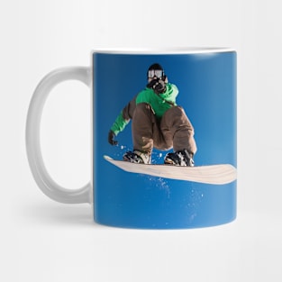 Snowboarder jumping against blue sky Mug